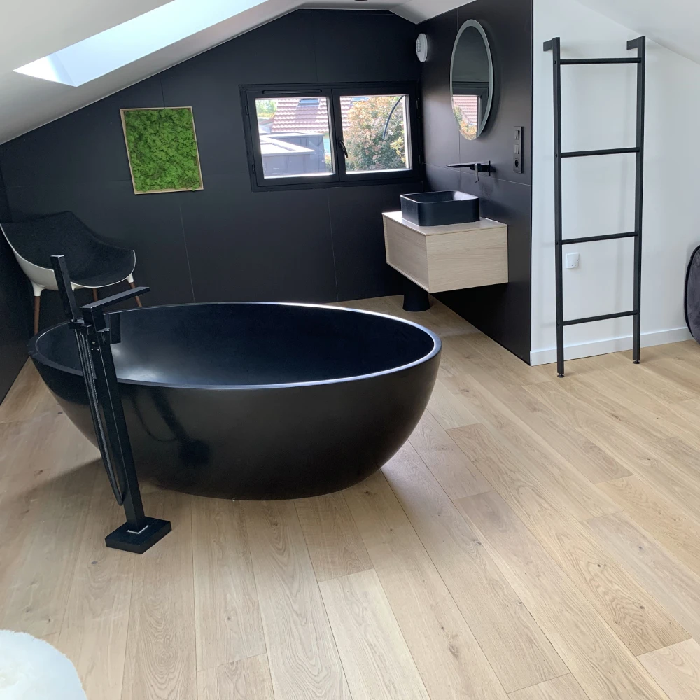 salle de bain de villa, détail du parquet en bois avec une baignoire noire